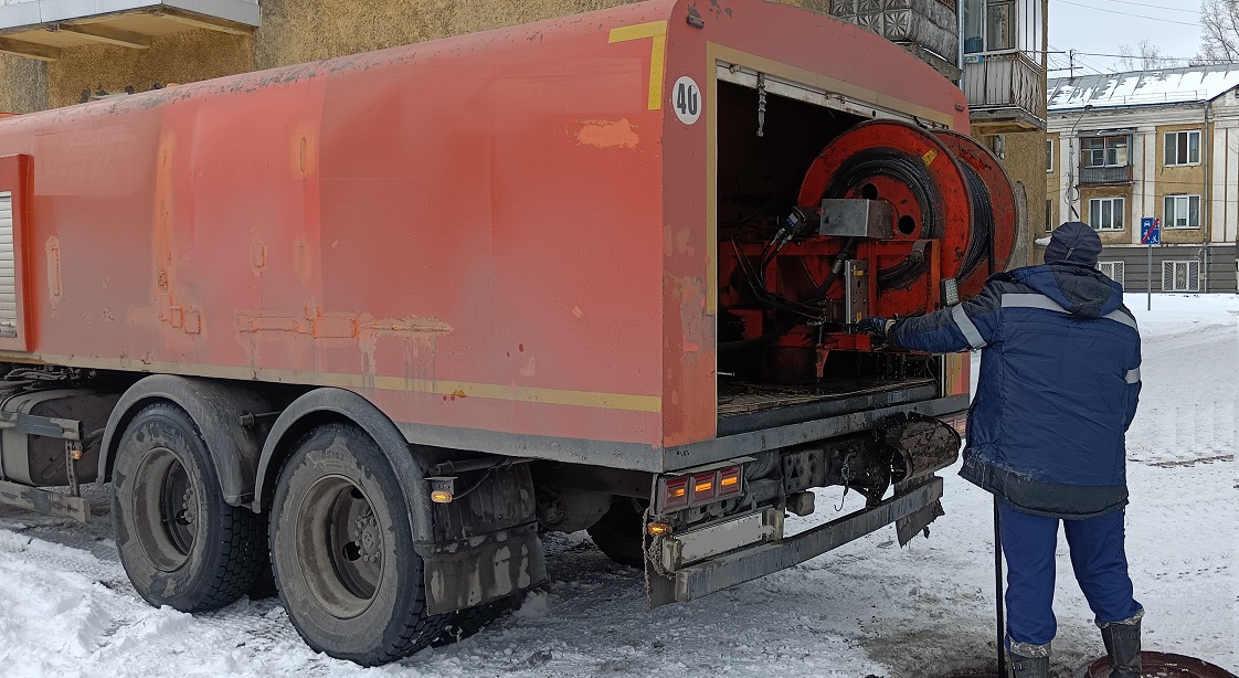 Каналопромывочная машина и работник прочищают засор в канализационной системе в Нарьян-Маре