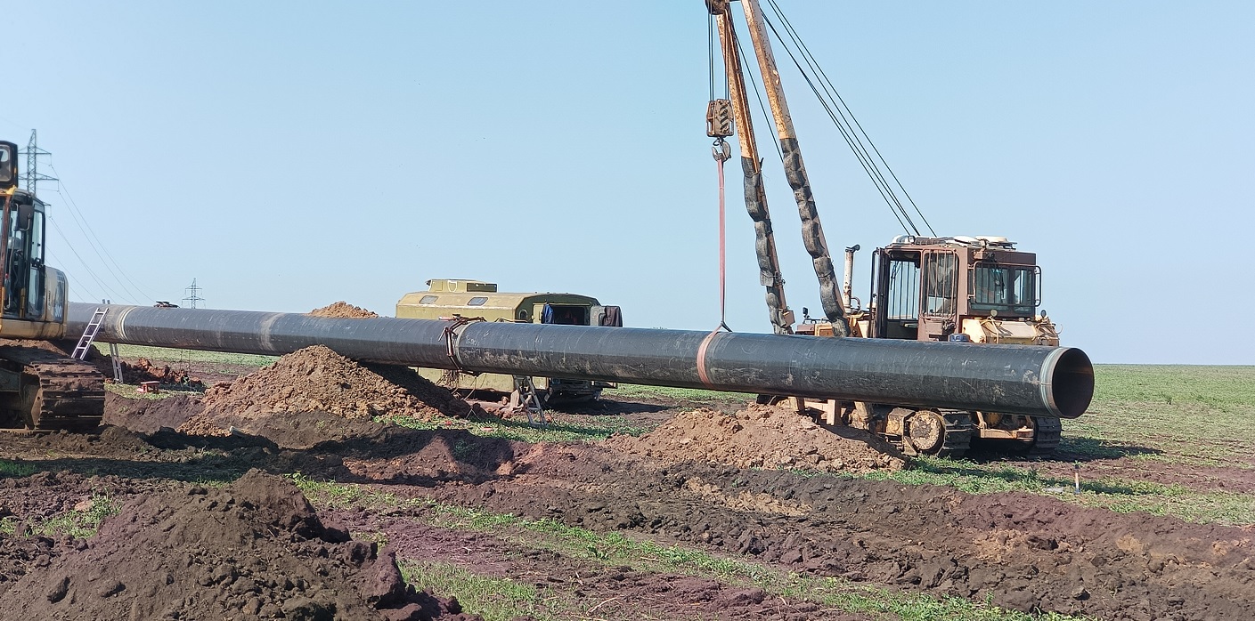 Трубоукладчик укладывает трубы в траншею в Ненецком АО